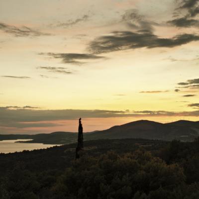 Weitblick über das Land. Die Sonne ist bereits untergegangen. Der Himmel leuchtet gelb und orange.