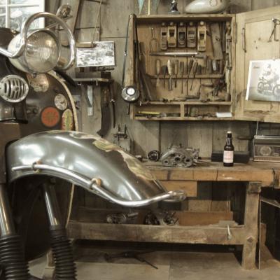 Ein alter Motorroller von Florett steht in einer rustikalen Werkstatt