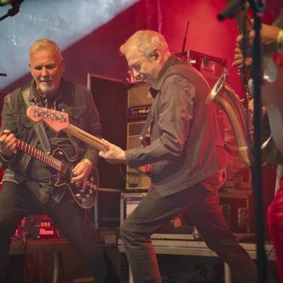 Zwei Bandmitglieder spielen E-Guitar auf der Bühne.